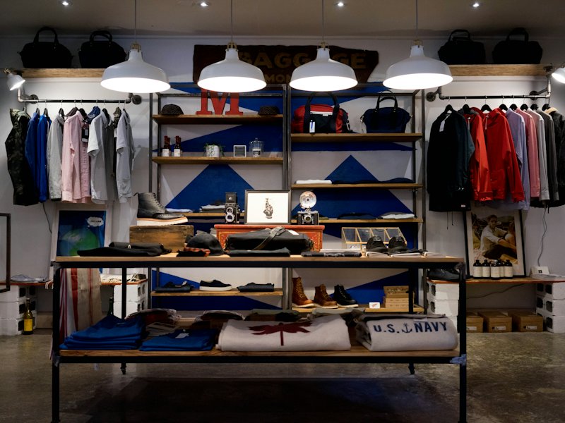 Boutique clothing store with shelves and pendant lights